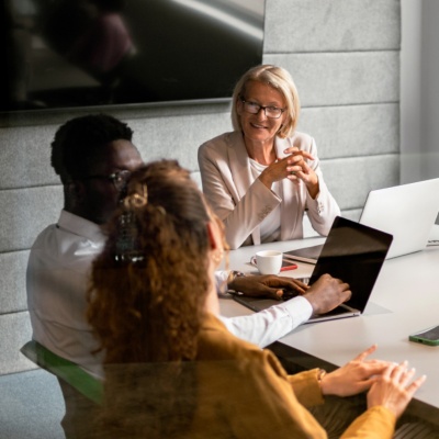 people in office meeting sitting around table
